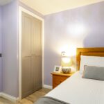 Bedroom with a fitted wardrobe and an open door through to the en-suite at Bridge House Care Home, Brighouse