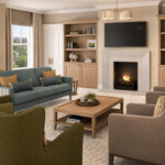 Artist's impression of a lounge with fireplace, bookshelves, sofa and armchairs at Elland Court Care Home, Leeds