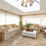 Orangery with roof lantern, cream sofas and floor-to-ceiling sheer curtains at The Maltings Care Home, Bridlington
