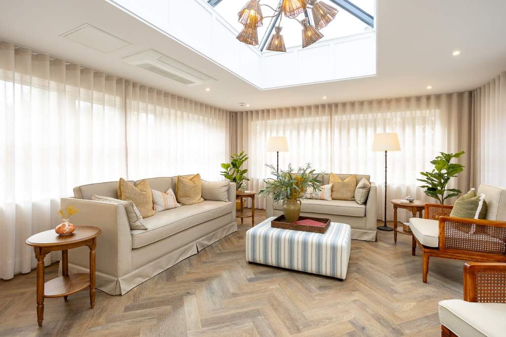 Orangery with roof lantern, cream sofas and floor-to-ceiling sheer curtains at The Maltings Care Home, Bridlington