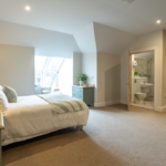 Large bedroom with dormer window and the door open to the en-suite shower room at The Maltings Care Home, Bridlington