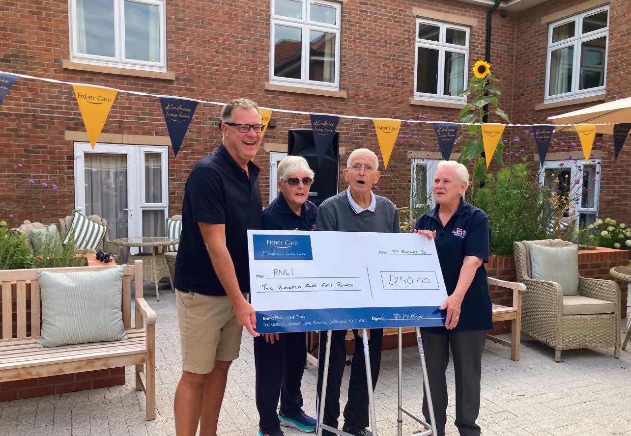 A £250 Fisher Care cheque being presented to the RNLI in the courtyard at The Maltings Care Home, Bridlington