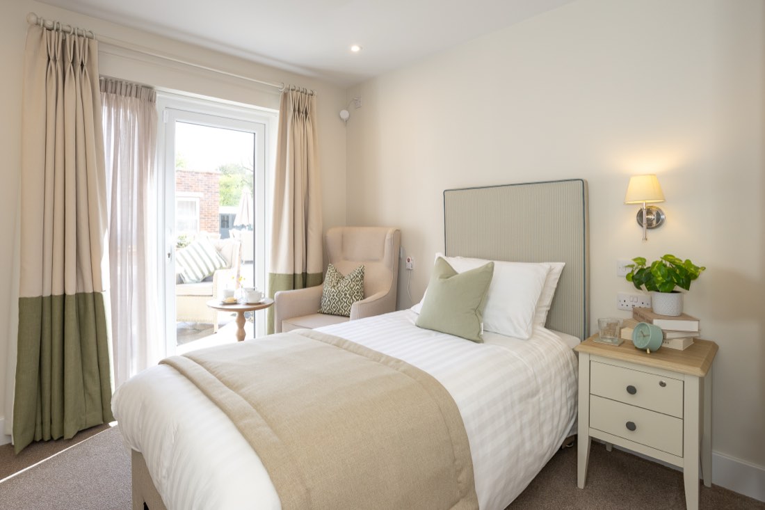 Single bedroom with an armchair and patio doors opening onto a garden terrace at The Maltings Care Home, Bridlington Single bedroom with an armchair and patio doors opening onto a garden terrace at The Maltings Care Home, Bridlington