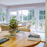 Dining room with laid tables overlooking the garden at Whitby Court Care Home, Whitby