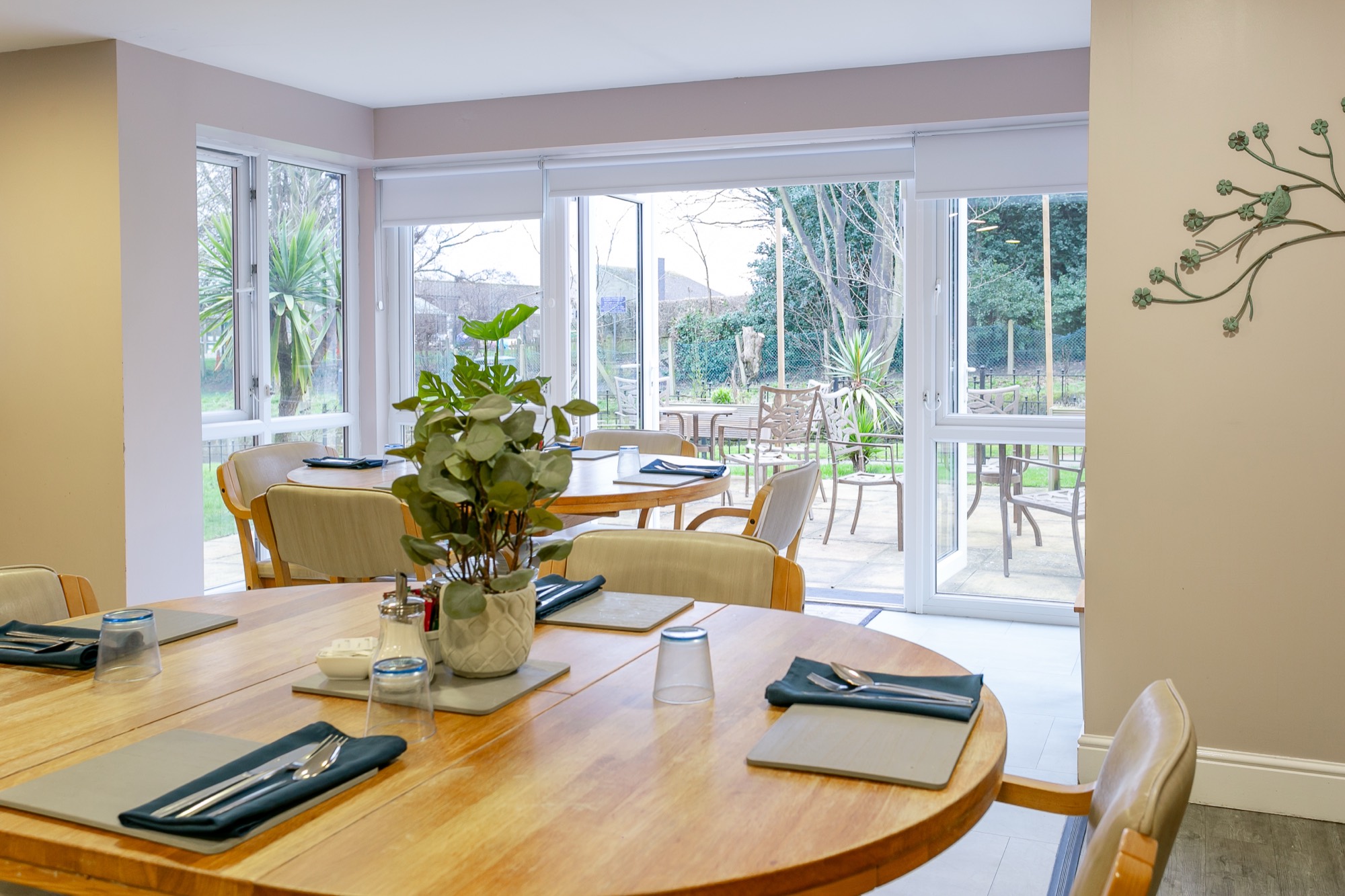 Dining room with laid tables overlooking the garden at Whitby Court Care Home, Whitby