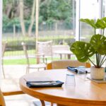 Dining table set for a meal beside doors to the garden patio at Whitby Court Care Home, Whitby