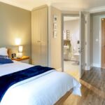 Bedroom with single bed and open en-suite door at Whitby Court Care Home, Whitby
